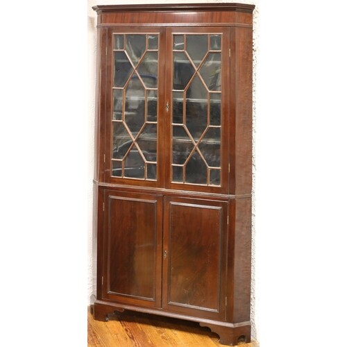A GEORGIAN MAHOGANY CORNER CABINET the moulded cornice above...
