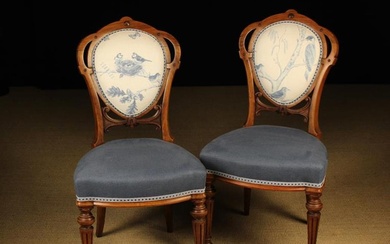 A Pair of Victorian Carved Walnut Medallion-back Chairs. The oval back frames ornamented with decora