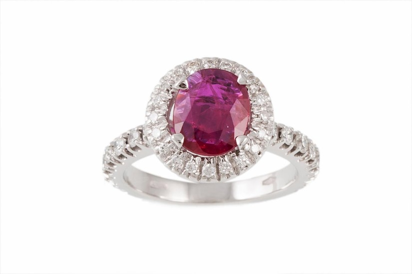 A RUBY AND DIAMOND CLUSTER RING, the cushion cut ruby to a b...