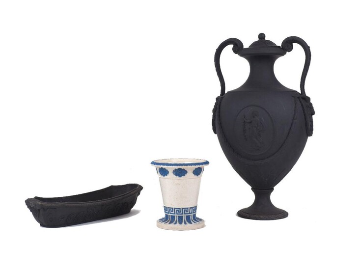 A Wedgwood black basalt twin handled urn, 19th century, designed with scroll handles terminating in ram's heads at the body, with oval medallions of classical females and applied laurel swags, impressed marks to the underside, the cover AF, 35cm...