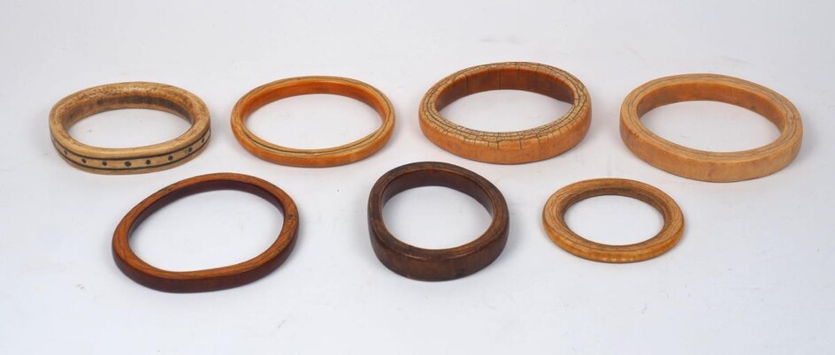 A group of large mixed African ivory bangles, 19th century, of varying patinas an sizes, some with additional decoration and various traditional repairs, one has additional metal terminals, largest 10cm wide (6)