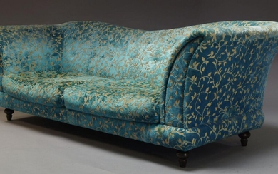 A large three seater sofa, upholstered in turquoise velvet and...