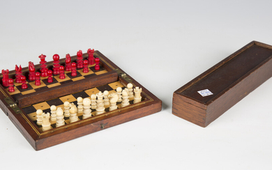 A late 19th/early 20th century ivory and red stained travelling chess set, height of king 3.5cm, mou