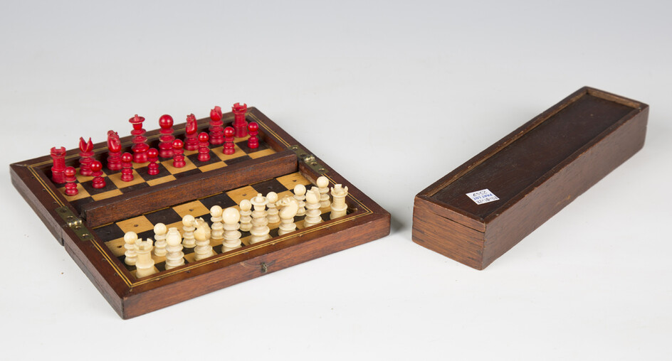 A late 19th/early 20th century ivory and red stained travelling chess set, height of king 3.5cm, mou