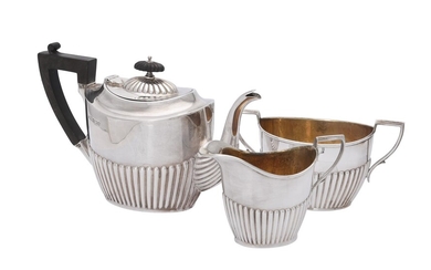 A matched Edwardian silver three piece oval half reeded three piece tea service by Joseph Rodgers &