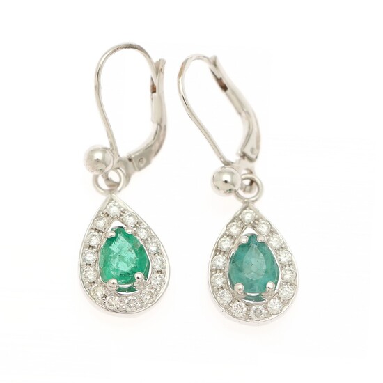 A pair of emerald and diamond ear pendants each set with a pear shaped emerald encircled by numerous brilliant-cut diamonds, mounted in 14k white gold. (2)