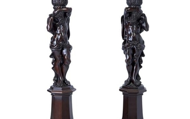 A pair of figural carved mahogany pedestals in the