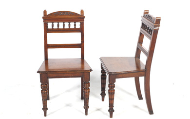 A pair of late Victorian walnut hall chairs.