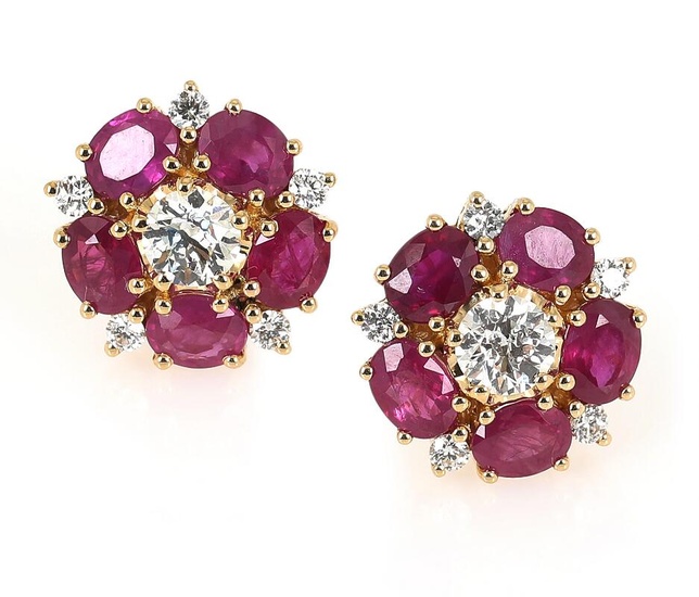 A pair of ruby and diamond ear studs each set with numerous...