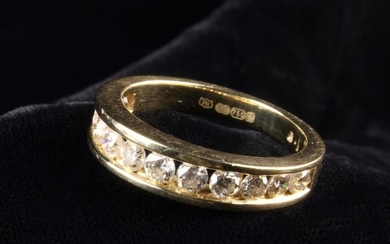 An 18 Carat Gold & Diamond Half Eternity Ring. The channel set front containing twelve round brillia