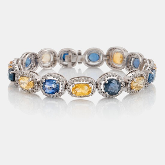 An 18K white gold bracelet set with faceted blue and yellow sapphires with a total weight of 25.80 cts