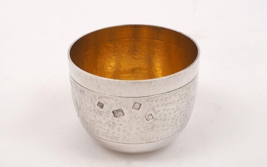 An Asprey & Co. silver tumbler cup, London, 1972, with hammered finish and gilded interior, designed with a textured band enclosing two circular medallions, one initialled 'C', 7.6cm dia., 6cm high, approx. weight 5.1oz