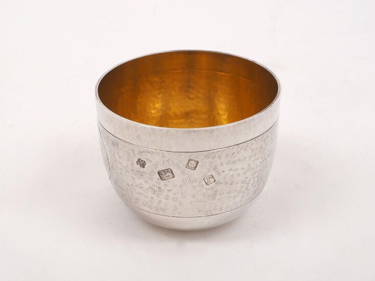 An Asprey & Co. silver tumbler cup, London, 1972, with hammered finish and gilded interior, designed with a textured band enclosing two circular medallions, one initialled 'C', 7.6cm dia., 6cm high, approx. weight 5.1oz