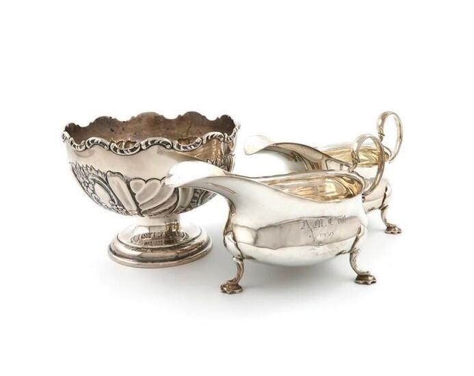 An Edwardian silver rose bowl, by Mappin and Webb, Birmingham 1903, circular form, part-fluted and scroll decoration, diameter 15.2cm, plus a pair of silver sauce boats, by Martin, Hall and Company, Sheffield 1912, oval form, wavy-edge border, scroll...