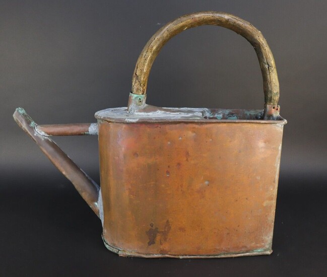 Copper watering can. Curved wooden handle. Absence of apple. Accidents and soldering. A second belly model is attached.
