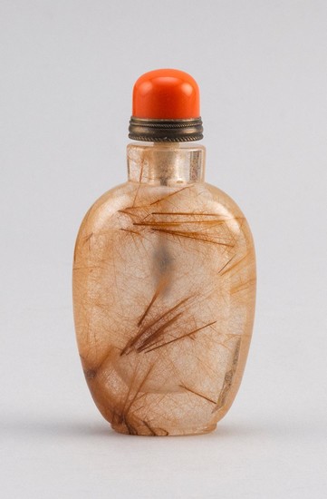 CHINESE ROCK CRYSTAL SNUFF BOTTLE In spade shape, with golden dendritic inclusions. Height 2.8". Simulated coral stopper.