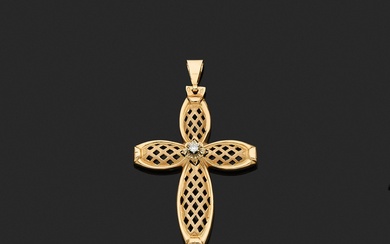 Croix-pendentif stylisée en or jaune 18K à décor de treillage ajouré, centrée d'un petit diamant...