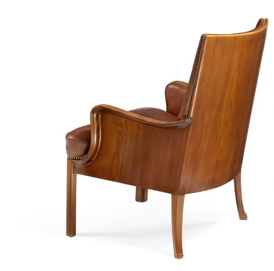 Frits Henningsen: Armchair with profiled Cuban mahogany frame with curvy armrests and hind legs. Upholstered with patinated brown leather.