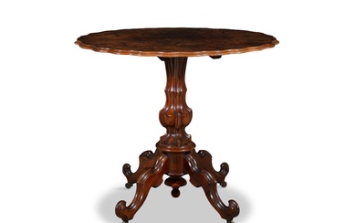 TABLE VICTORIENNE EN NOYER, de forme ovale, plaquée en quart sur une colonne centrale sculptée...