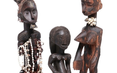 Three ancestor figures of carved patinated wood mounted with beads and clad with brass plates, cloth and feathers. Luba, Fang and Bambara style. H. 35–51 cm.