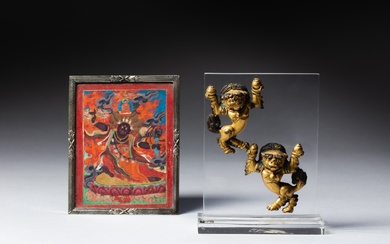Two gilt-bronze figures of lions and a small thangka depicting...