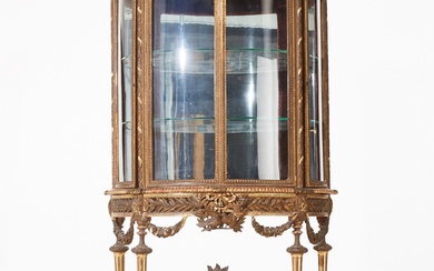 Vitrine en bois dore de style Louis XVI. Presente un ensemble de decor festif sur...