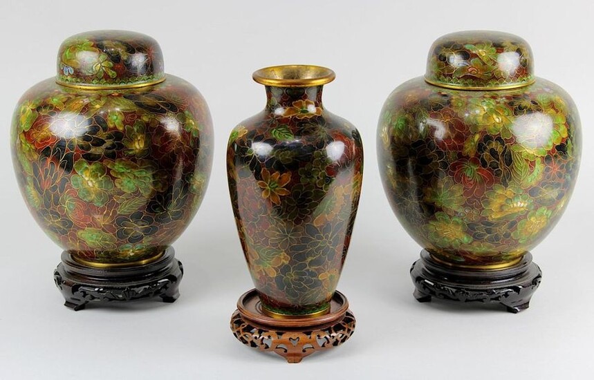 3 Cloisonné vases, China mid-20th century: Pair of lidded vases and 1 vase, all with very similar decoration of flowers on reddish brown background, on round wooden stands, H lidded vases each 20.5 cm, vase 20 cm. 2483-018