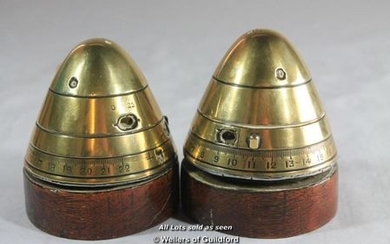 A pair of trench art paperwweights modelled from brass shell heads, with additional wooden plinths.