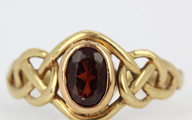 9CT YELLOW GOLD AND GARNET RING.
