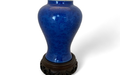 A 19th century Chinese porcelain blue self patterned monochrome baluster vase on a pieced hardwood