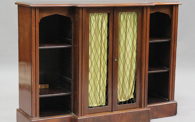 A 19th century mahogany breakfront bookcase cabinet, enclosed by two trellis panel doors, flanked by