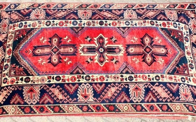 A 20TH CENTURY PERSIAN CARPET, the red ground central