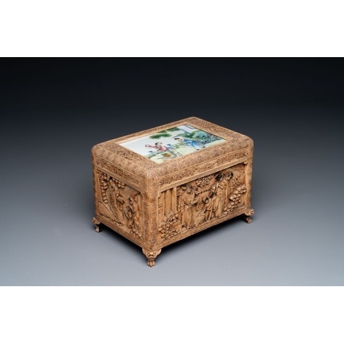 A Chinese Canton carved wooden casket with a famille rose pl...