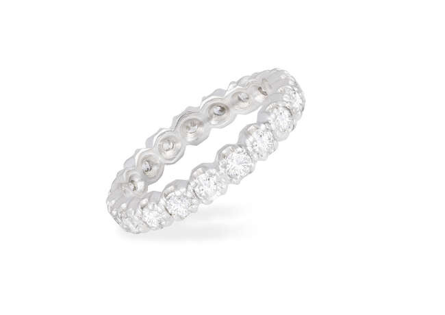 A DIAMOND ETERNITY RING Composed of a continuous...