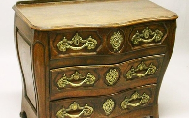 A LOUIS XV STYLE FRENCH OAK SERPENTINE FRONT COMMODE