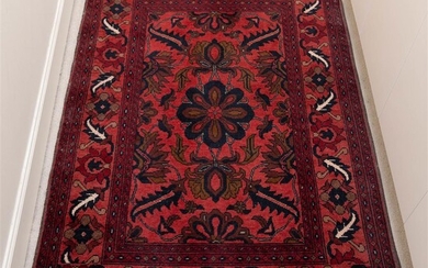 A Persian carpet of stylized geometric floral design on a...