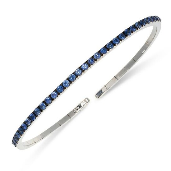 A SAPPHIRE BANGLE of flexible construction, set to the