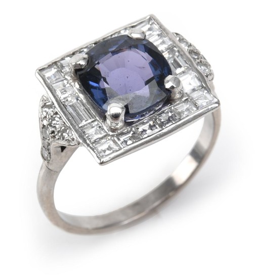 A SPINEL AND DIAMOND RING - Of Art Deco style, featuring a cushion cut blue spinel weighing an estimated 3.50cts, within a border of...