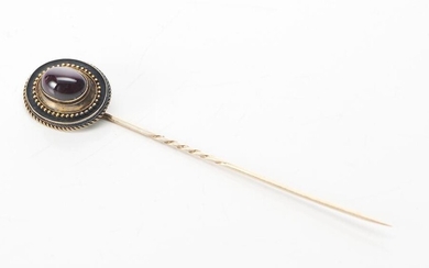 A TIE STICK PIN CENTRALLY SET WITH A GARNET CUT EN CABOCHON IN A DECORATIVE SURROUND, IN 15CT GOLD, LENGTH 85MM, 4GMS