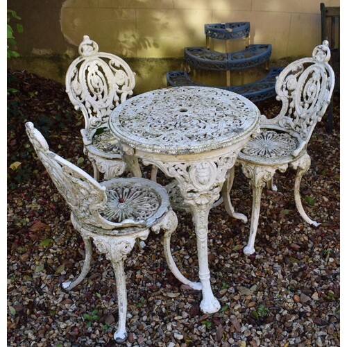 A Victorian style painted cast metal garden table, three mat...