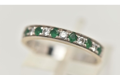 A WHITE METAL EMERALD AND DIAMOND HALF ETERNITY RING, set wi...