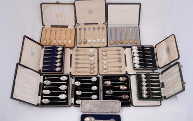 A collection of twelve cased sets of silver and silver coloured spoons