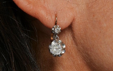A diamond and gold pair of ear pendants.