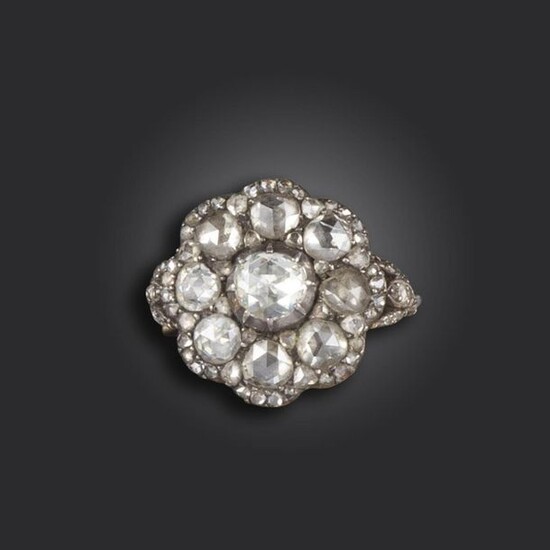 A diamond cluster ring, of flowerhead design and set with rose-cut diamonds in silver on gold closed-back setting, with further diamonds to the foliate shoulders, size M approximately