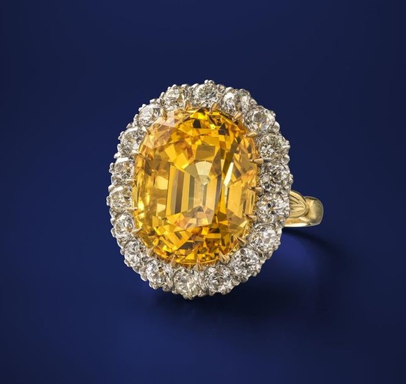 A fine yellow sapphire and diamond cluster ring,...