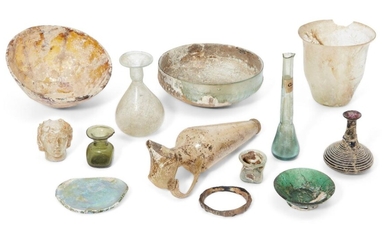 A group of glass vessels Hellenistic-Roman periods and Later, including a damaged Hellenistic amber glass mammiform bowl, 12.5cm diam; a damaged and restored miniature bottle with white trail decoration around the glass body, 6cm high; a pale blue...