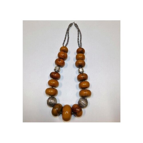 A large ethnic amber necklace with white metal fittings, tes...