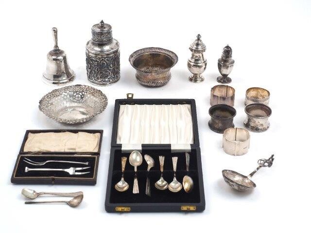 A mixed group of small silver and white metal including: a silver tea caddy, London, 1901, Mappin Bros, 12.2cm high; a cased pair of silver pickle forks, Chester, 1929, Charles Perry & Co.; a cased set of six silver coffee spoons; a bell...