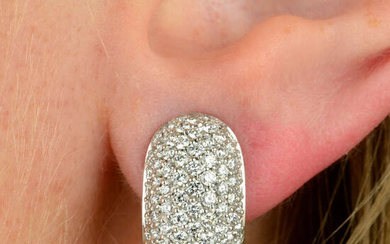 A pair of pave-set diamond hinged hoop earrings.