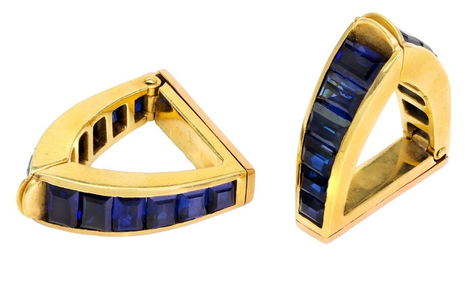 A pair of sapphire cufflinks, by Sanz, each of hinged stirrup design channel set with a graduated line of calibre-cut sapphires, signed Sanz.